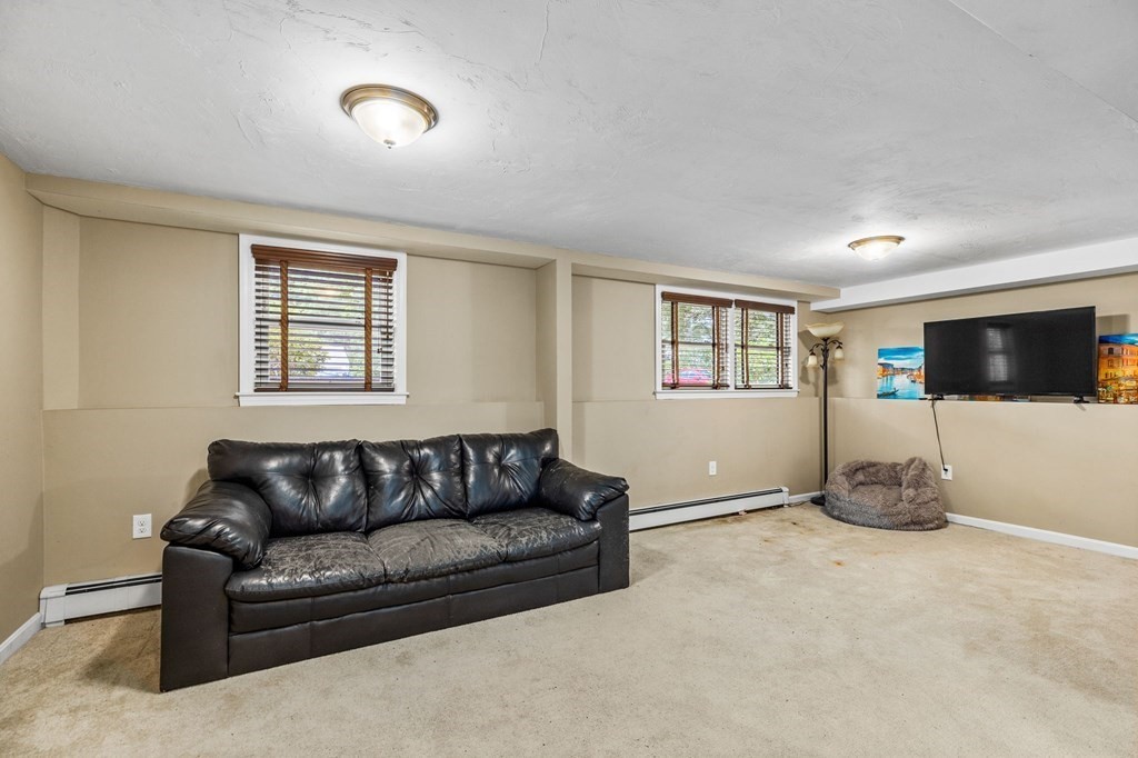 17 Pinetree Road Stoughton, MA 02072 - Photo 22 of 34 a living room with furniture a flat screen tv and a window