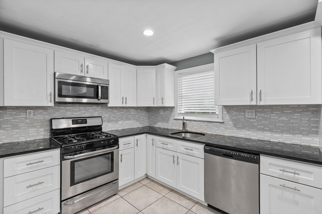 17 Pinetree Road Stoughton, MA 02072 - Photo 3 of 34 a kitchen with granite countertop white cabinets appliances and a sink