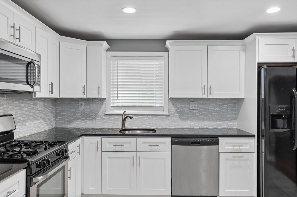 17 Pinetree Road Stoughton, MA 02072 - Photo 4 of 34 a kitchen with granite countertop white cabinets and stainless steel appliances
