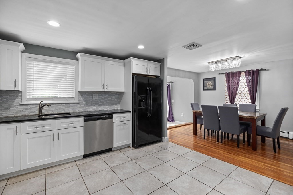 17 Pinetree Road Stoughton, MA 02072 - Photo 5 of 34 a kitchen with granite countertop a refrigerator a stove a dining table and chairs