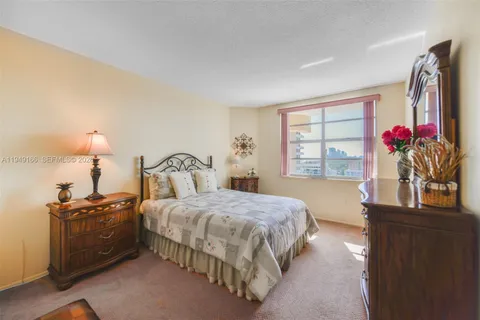 a bedroom with a bed and a flat tv screen on dresser