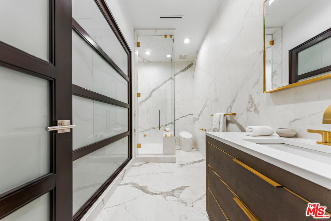 9374 Beverlycrest Drive Beverly Hills, CA 90210 - Photo 13 of 24 a bathroom with a sink a mirror and a shower