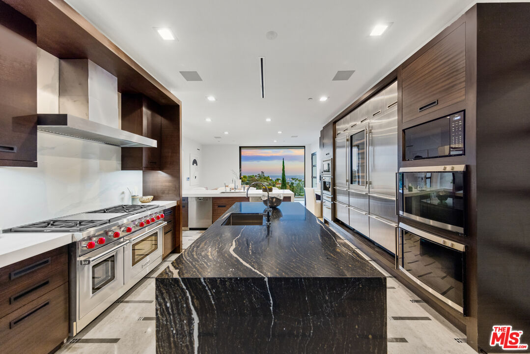 9374 Beverlycrest Drive Beverly Hills, CA 90210 - Photo 10 of 24 a kitchen with stainless steel appliances granite countertop a stove a sink dishwasher and cabinets with wooden floor