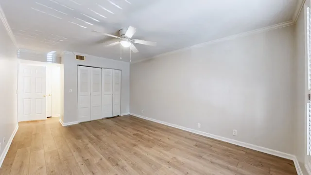 a view of an empty room with wooden floor