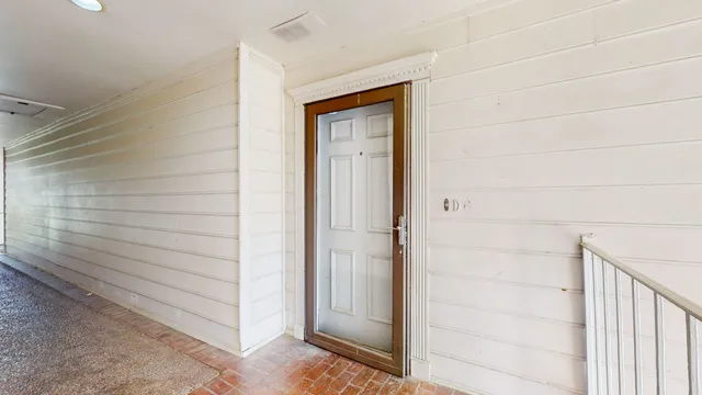 a view of a hallway with wooden floor and chandelier