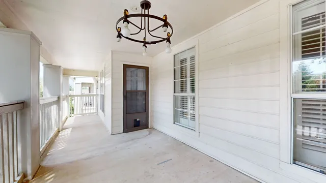 a view of a porch with wooden floor and windows