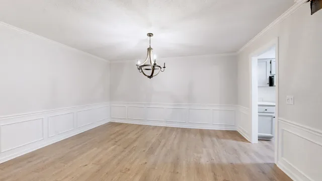 a view of a room with wooden floor and white walls