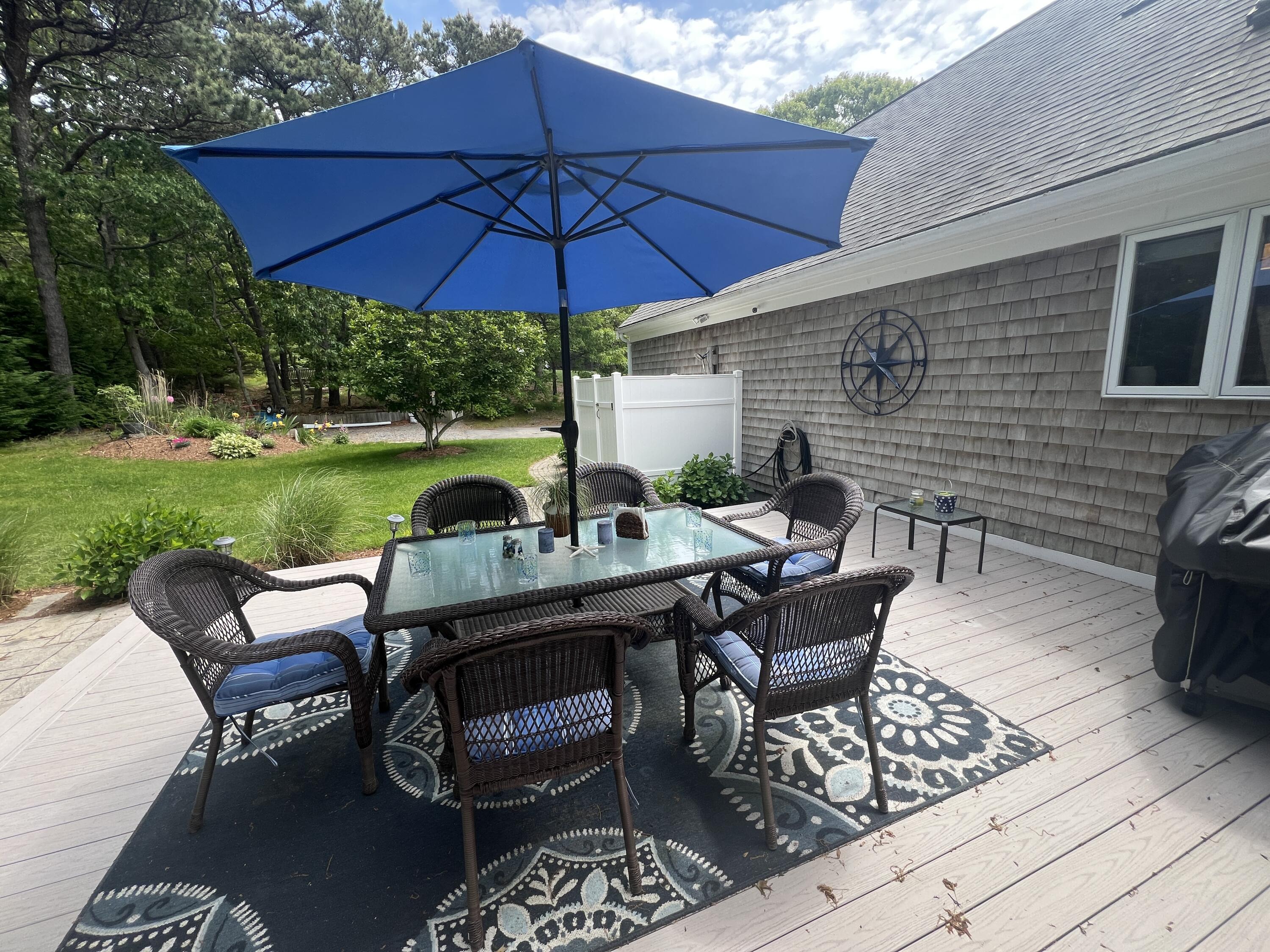 32 Apple Lane Dennis, MA 02638 - Photo 36 of 48 a patio with tables and chairs under an umbrella