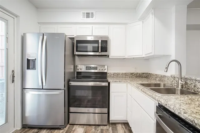 a kitchen with stainless steel appliances granite countertop a refrigerator sink and microwave