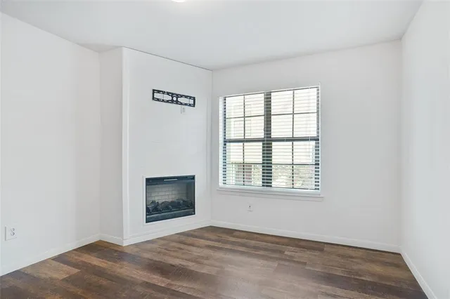 a view of an empty room with a window and fireplace