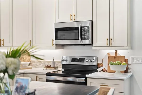 a kitchen with appliances a stove and cabinets