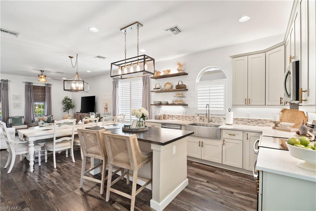3060 Woodside Avenue Naples, FL 34112 - Photo 13 of 36 a kitchen with lots of counter space and dining table