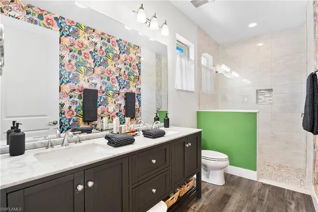 a bathroom with a granite countertop sink and a toilet