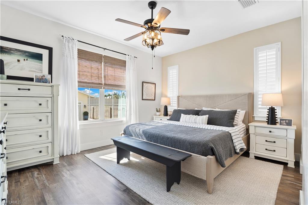3060 Woodside Avenue Naples, FL 34112 - Photo 15 of 36 a bedroom with a bed a chandelier and a window