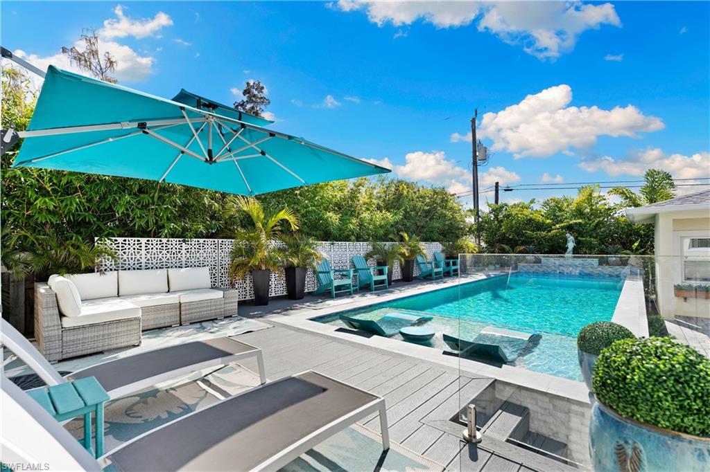 3060 Woodside Avenue Naples, FL 34112 - Photo 24 of 36 a view of a patio with a table and chairs under an umbrella