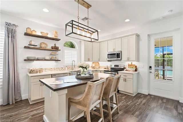 a living room with furniture a flat screen tv and a view of kitchen