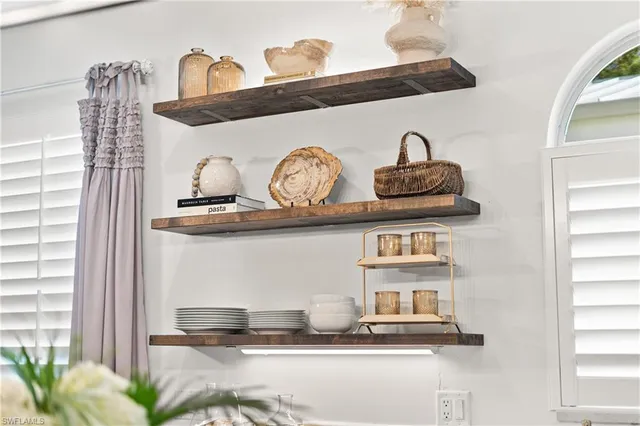 a living room with furniture kitchen view and a chandelier