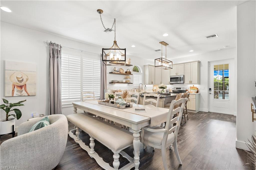 3060 Woodside Avenue Naples, FL 34112 - Photo 7 of 36 a view of a dining room and livingroom with furniture wooden floor a chandelier