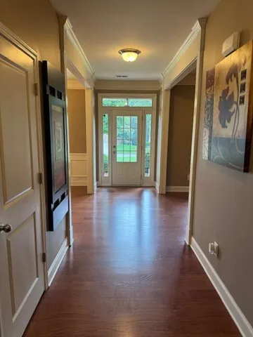 a view of hallway with stairs and wooden floor