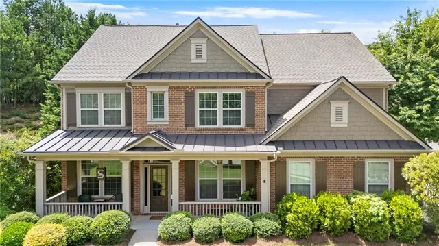 a front view of a house with a yard and potted plants