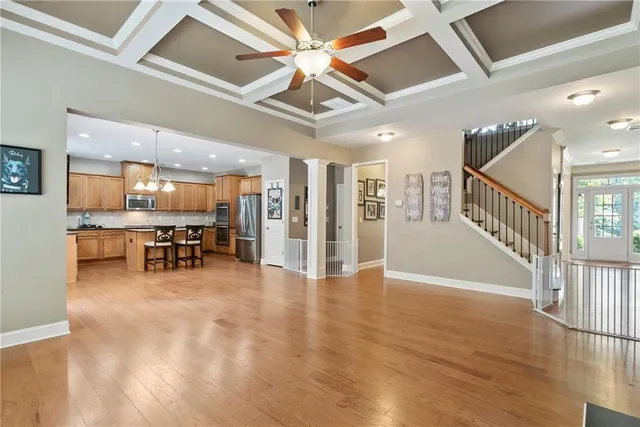 a view of an empty room with kitchen view