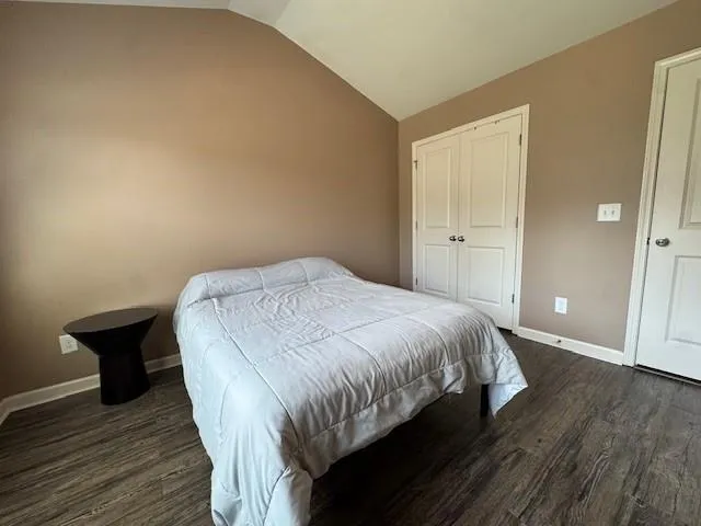 a bed sitting in a spacious bedroom next to a bathroom
