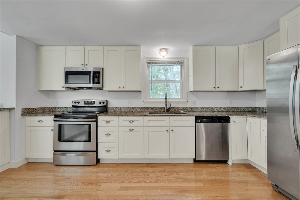 32 Dewey Road Lexington, MA 02420 - Photo 12 of 32 a kitchen with stainless steel appliances granite countertop a stove a sink and a microwave