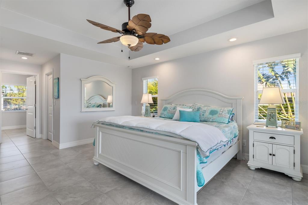 259 Marker Road Rotonda West, FL 33947 - Photo 14 of 37 a bedroom with a large bed and a chandelier fan