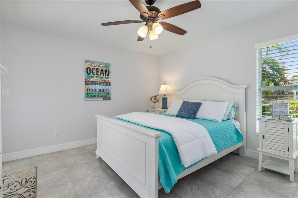 259 Marker Road Rotonda West, FL 33947 - Photo 18 of 37 a bedroom with a bed and a chandelier