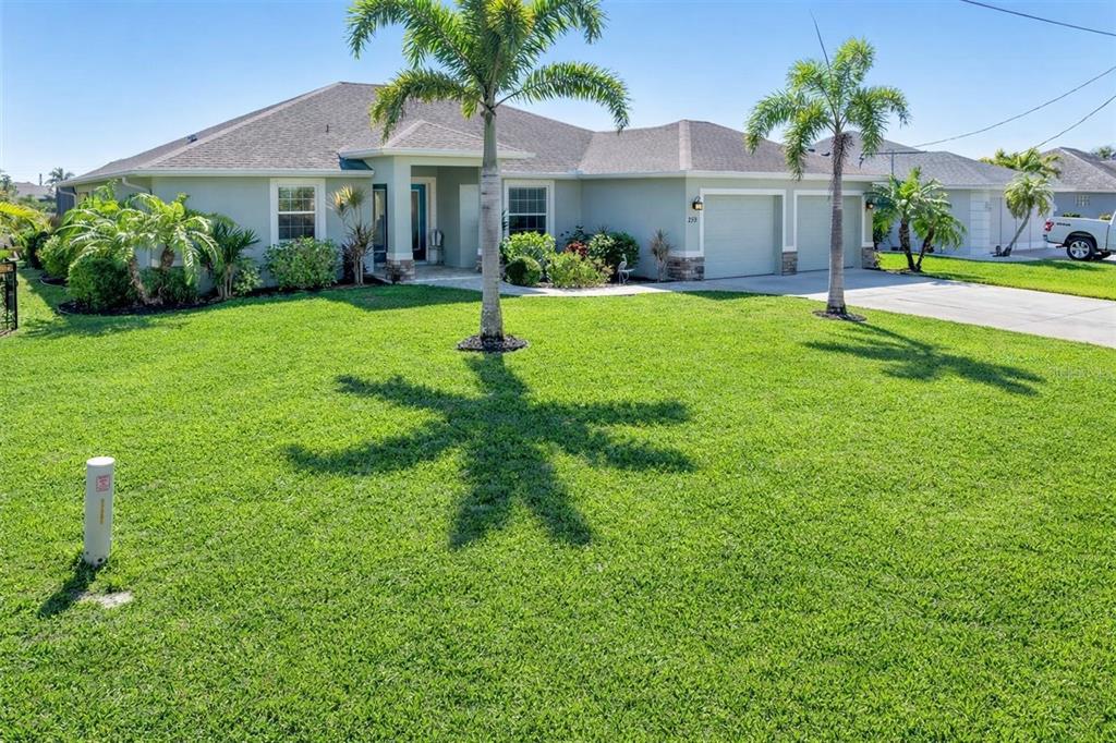 259 Marker Road Rotonda West, FL 33947 - Photo 30 of 37 a front view of a house with a yard and garage
