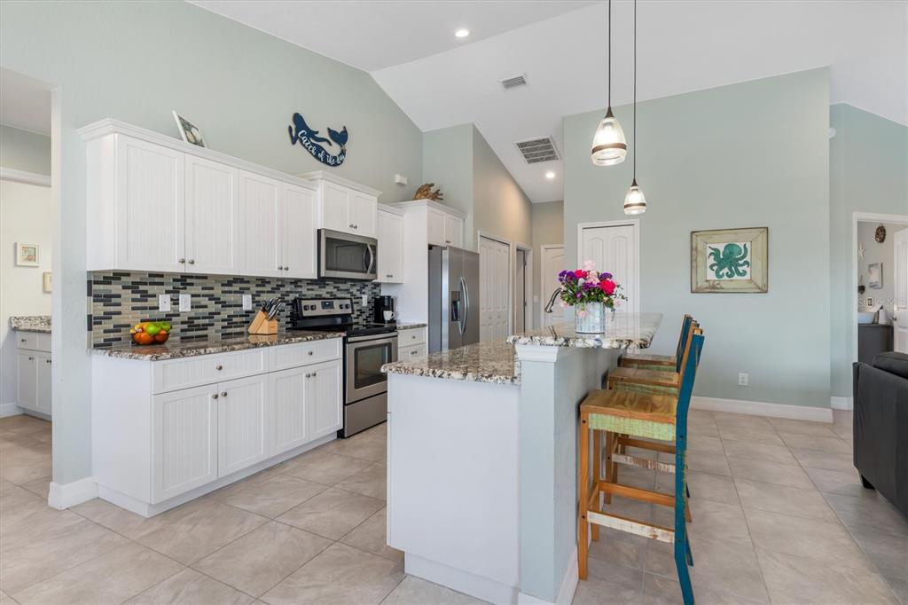 259 Marker Road Rotonda West, FL 33947 - Photo 8 of 37 a kitchen with stainless steel appliances kitchen island granite countertop a sink and cabinets