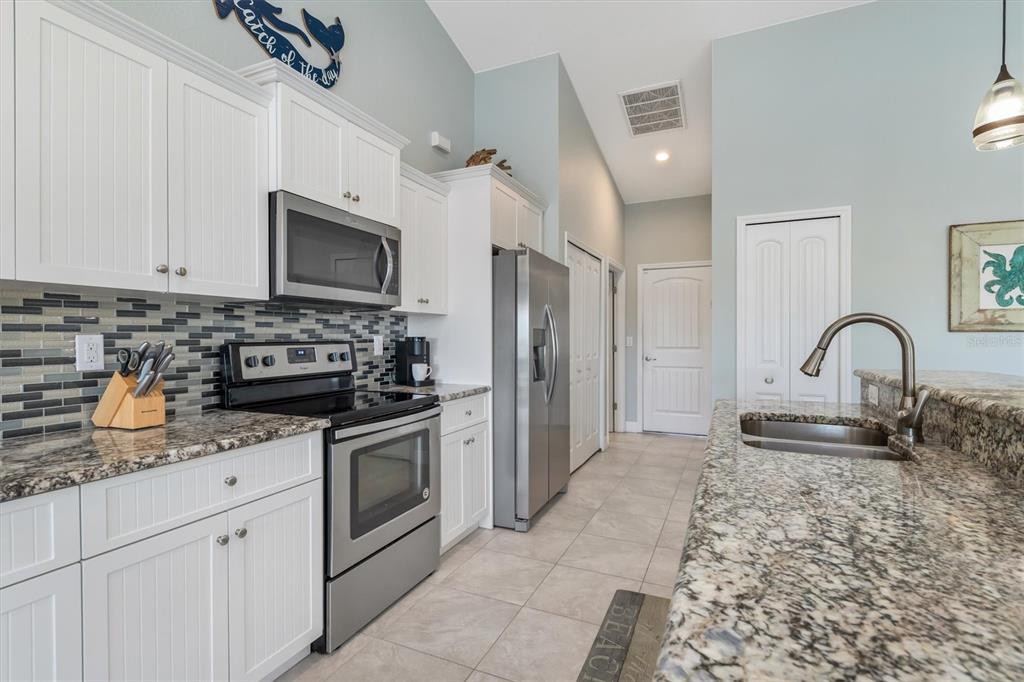 259 Marker Road Rotonda West, FL 33947 - Photo 9 of 37 a kitchen with stainless steel appliances granite countertop a stove a sink and a refrigerator