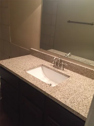 a bathroom with a granite countertop sink and vanity
