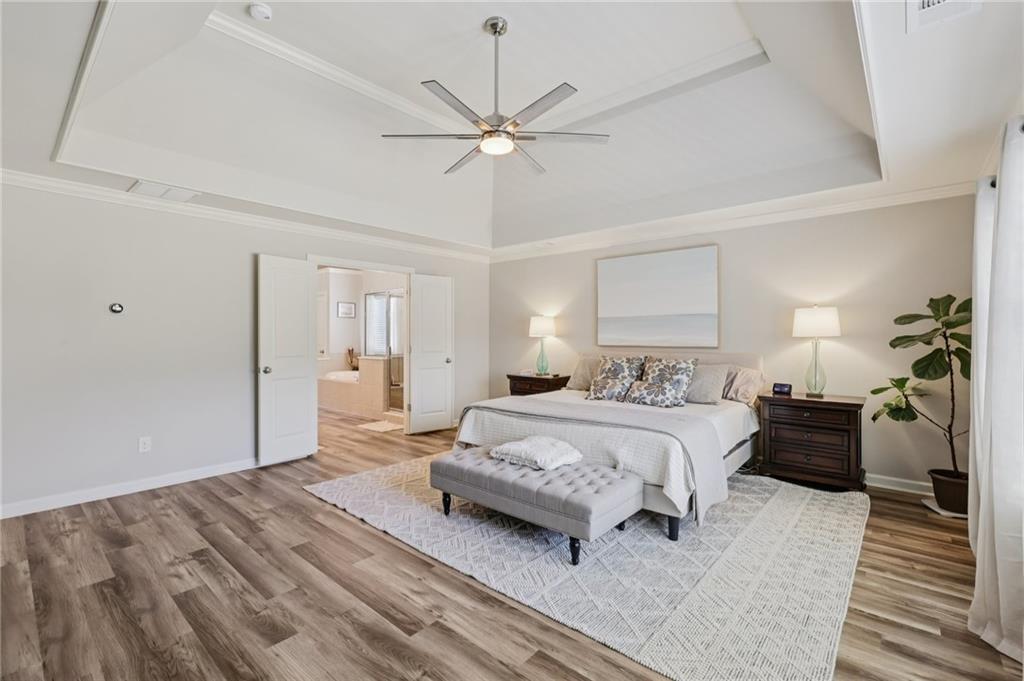 5775 Cascade Trail Cumming, GA 30040 - Photo 19 of 49 a spacious bedroom with a bed and a chandelier