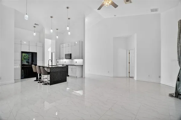 a kitchen with a sink a stove a refrigerator and chairs