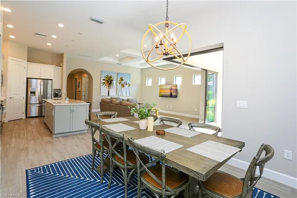 a view of a dining room with furniture a chandelier and wooden floor