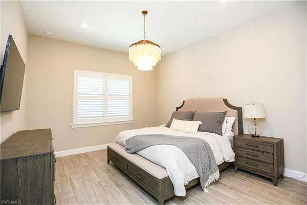 a bedroom with bed and a chandelier
