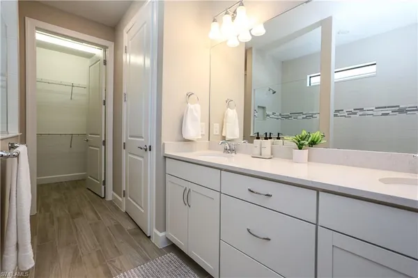 a bathroom with a double vanity sink mirror and shower