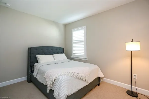 a bedroom with a bed and a lamp