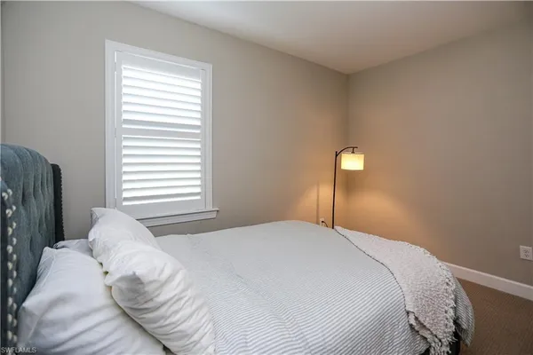 a bedroom with a bed and a lamp