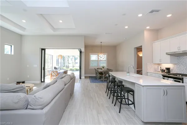 a living room with furniture a dining table and chairs with wooden floor