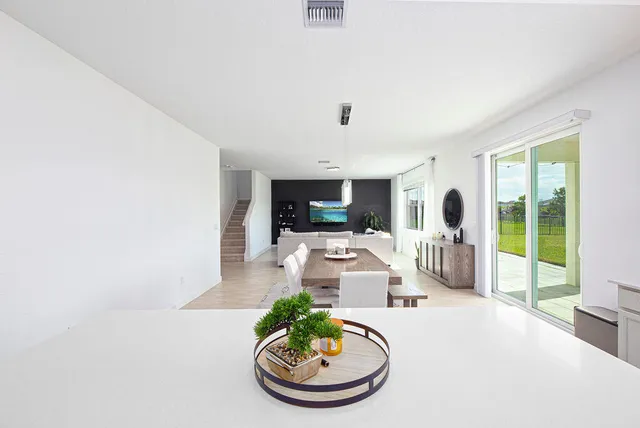 a kitchen with a refrigerator a stove a sink a stove a dining table and chairs