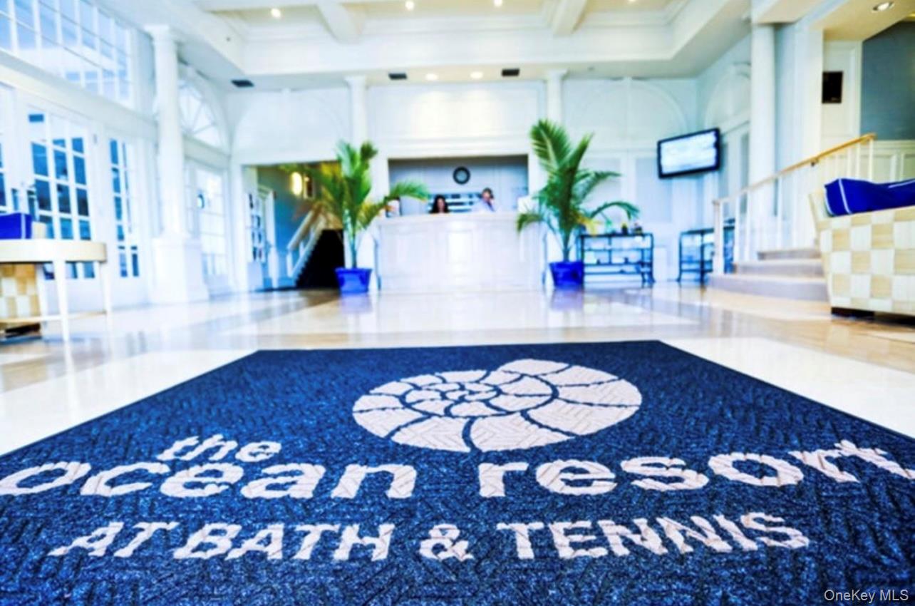 231 Dune Road, Unit 905 Westhampton Beach, NY 11978 - Photo 11 of 24 Building lobby featuring a high ceiling, beam ceiling, and stairs