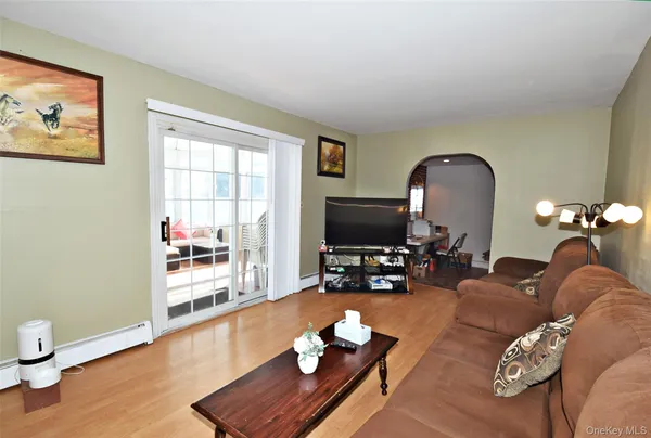 a living room with furniture a flat screen tv and wooden floor