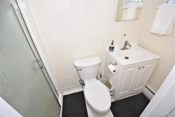 a white toilet sitting next to a white sink and vanity