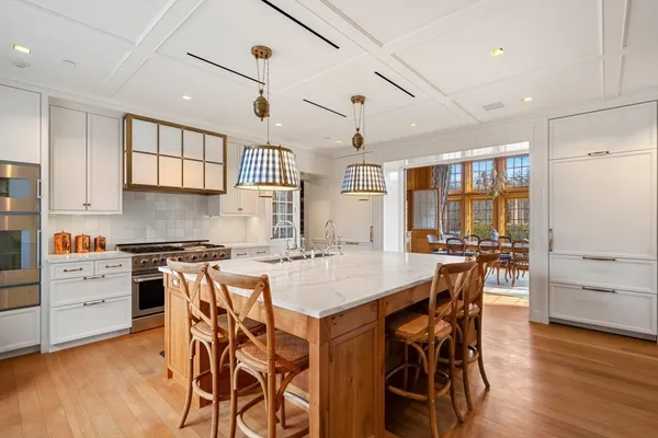 a kitchen with stainless steel appliances a stove a table and chairs