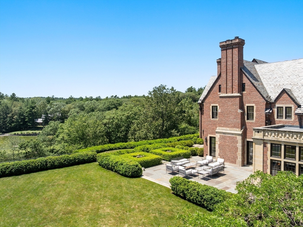 4 Willow Road Weston, MA 02493 - Photo 16 of 42 a front view of a house with a yard table and chairs