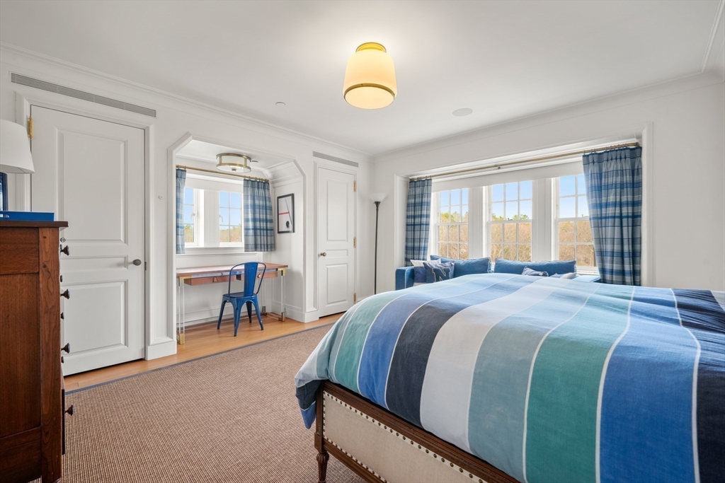 4 Willow Road Weston, MA 02493 - Photo 30 of 42 a bedroom with a bed and a chandelier