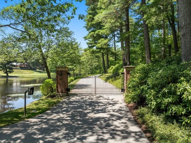 a view of a white house with a big yard and potted plants