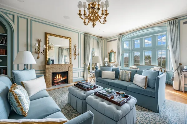 a living room with furniture fireplace and a large window